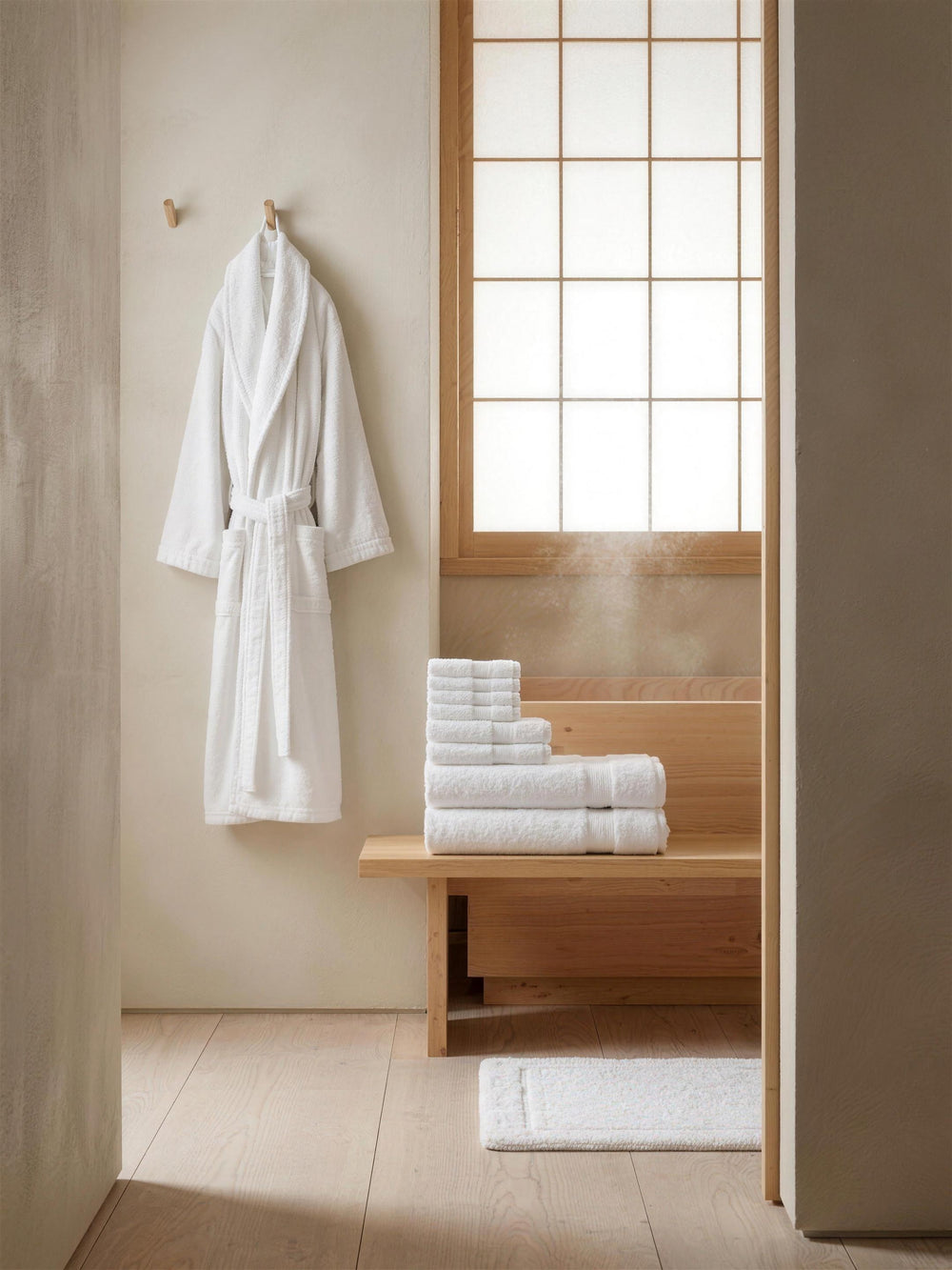 Matching set: robe, towel stack and mat in a bathroom alcove