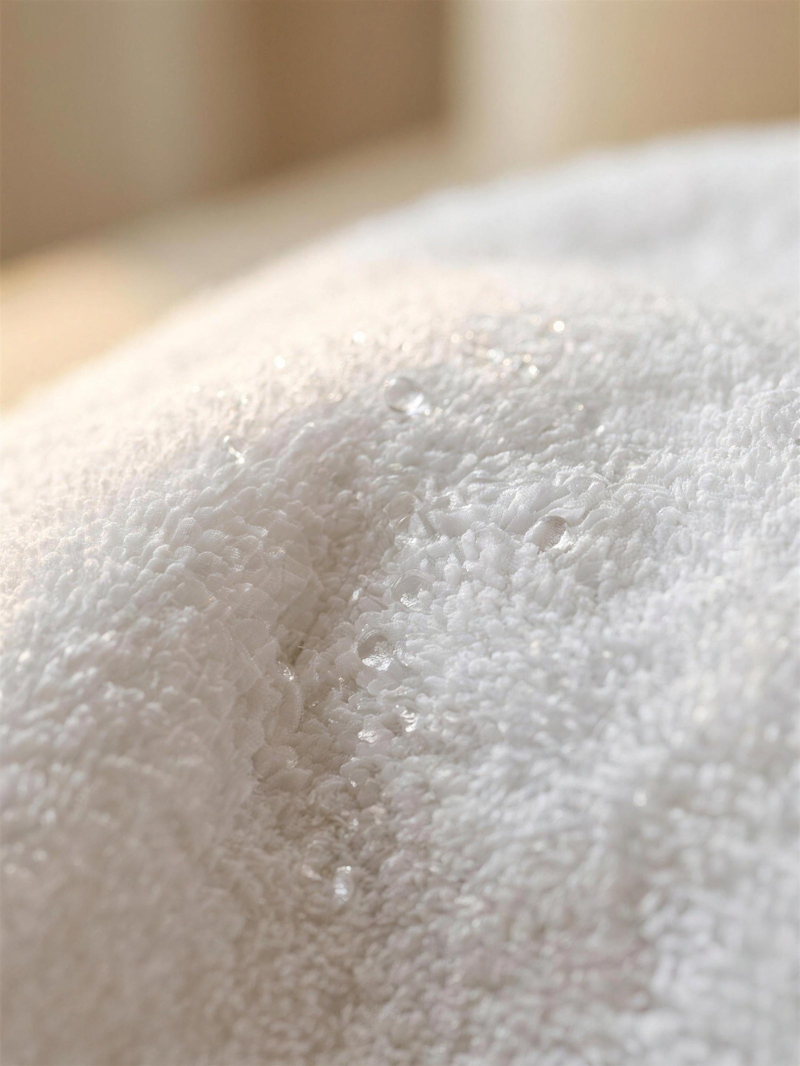 Close-up of dense terry pile absorbing water droplets